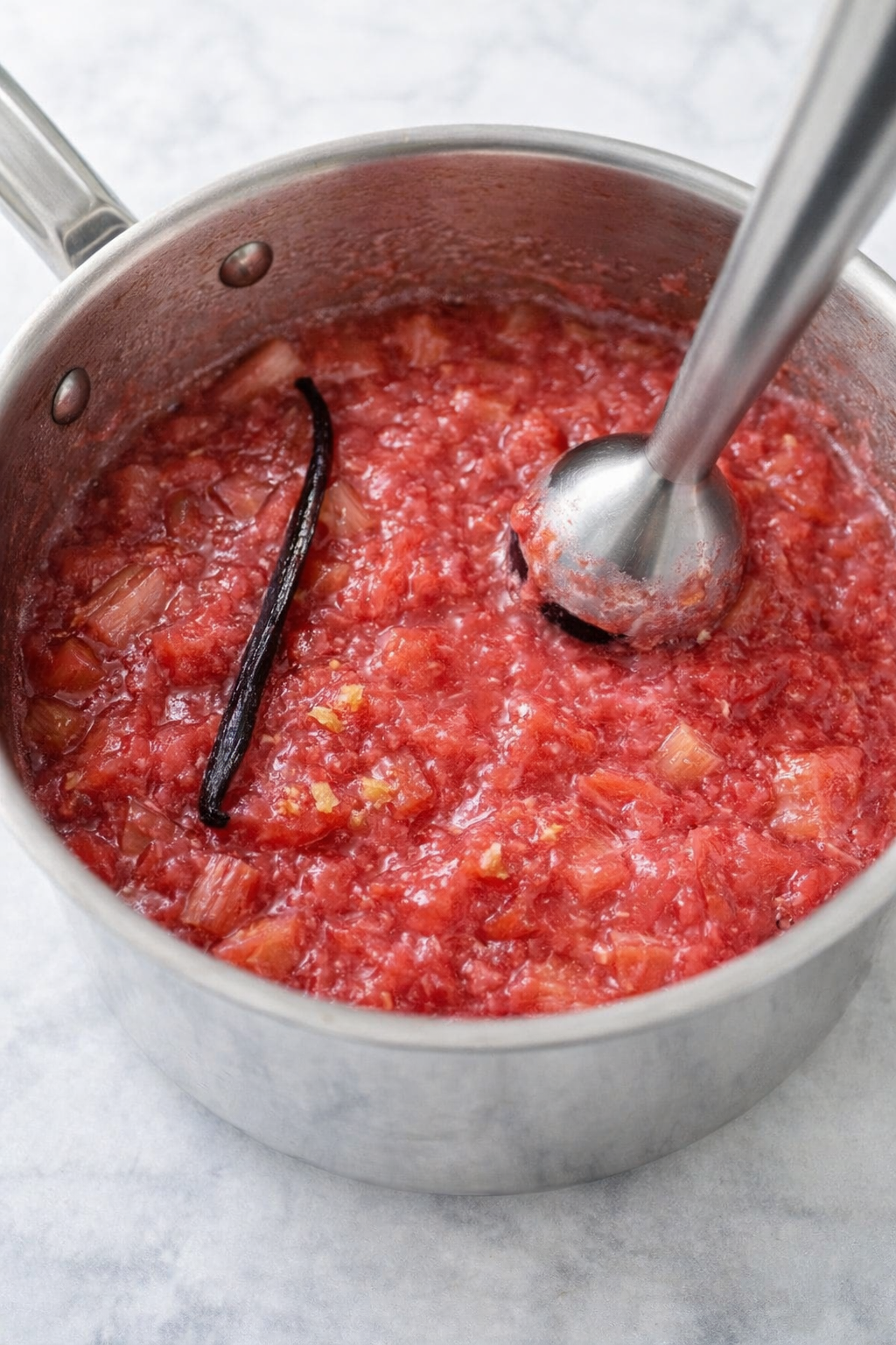 Chopped rhubarb macerating with sugar, then simmering in a saucepan with vanilla until soft.